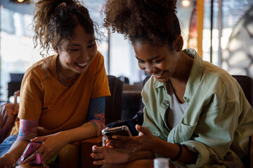 Friends looking at social media together while in cafe