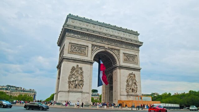 Iconic triumphal arch with the French flag in Paris, France. Historical and architectural landmark of Paris on a sunny summer day.