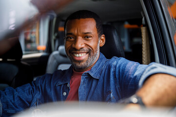 Happy man looks out of the window of a car