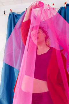 Non binary person with pink veil in studio