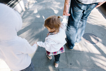 View from behind of family walking and holding hands