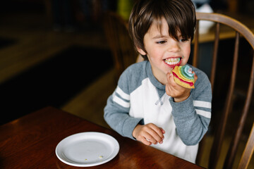Boy eats rainbow cookie
