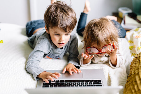 Kids play on laptop and reading glasses