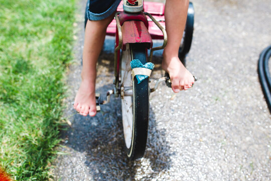 Child pedals bike with heart taped to wheel