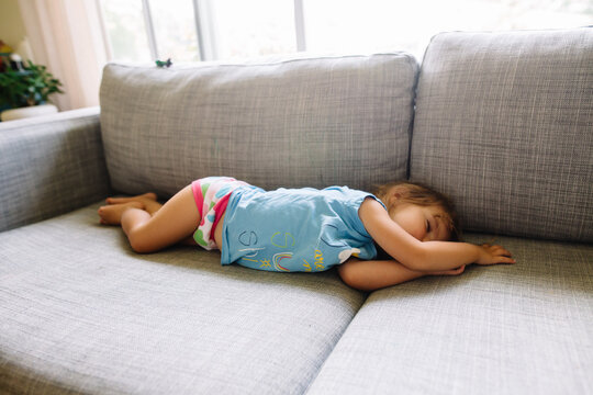 Toddler girl sleeps on couch