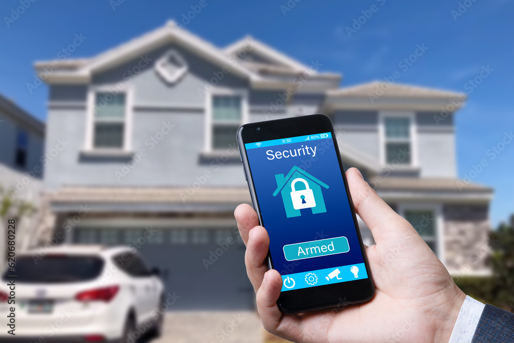 Poster smartphone with home security app in a hand on the building background.