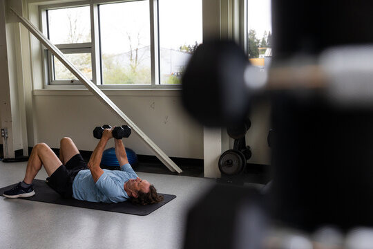 Mature man working out with dumbbells in the gym.