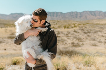 Man loves dog in the desert