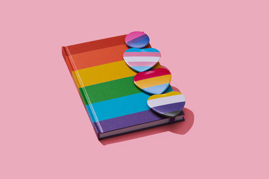 LGBTIQ pride badges and notebook patterned with a rainbow flag