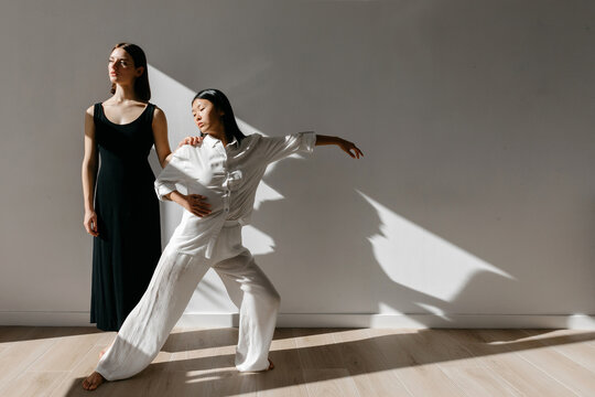 Graceful Asian ballerina dancing in studio