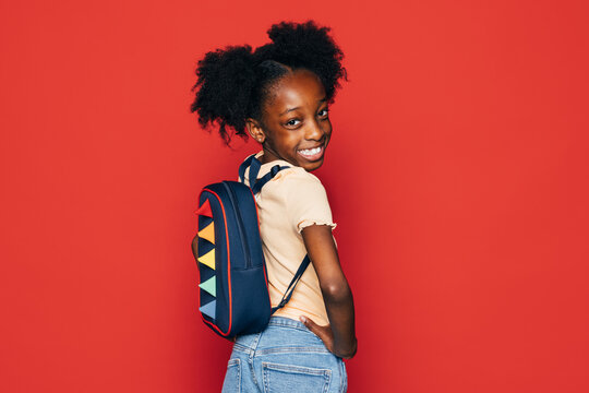 Smiling black schoolgirl with backpack