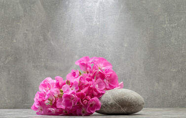 gray zen stones and pink flowers on a gray background for product presentation podium background