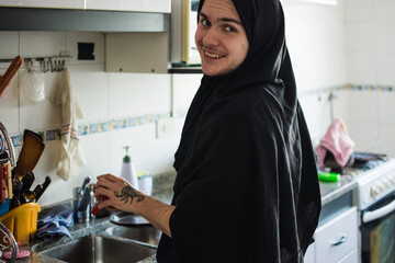 Happy non-binary person washing the dishes