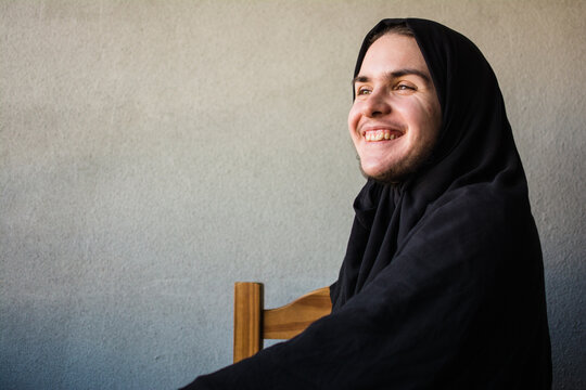 Fun non-binary person smiling and wearing hijab