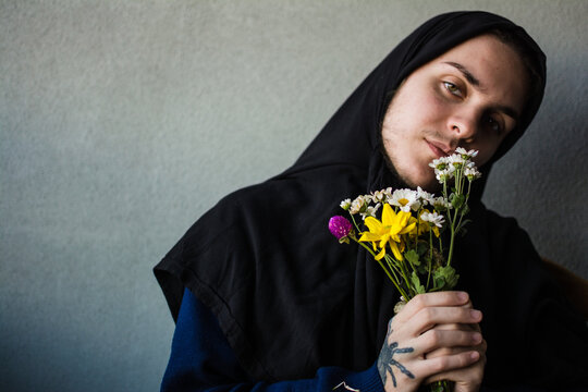 Confident trans muslim person holding flowers