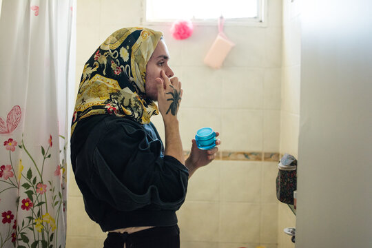 Muslim person applying hydrating gel with hyaloronic acid