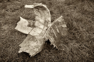 Summer day, on the grass is an old fiberglass composite coating that covered the flange connection...