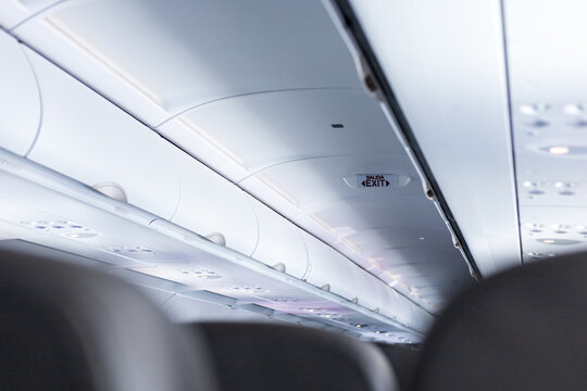 A Sign Indicating The Emergency Exits Inside An Airplane