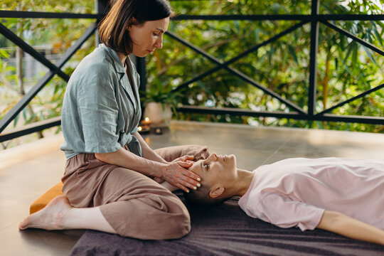 Woman practicing reiki therapy on client