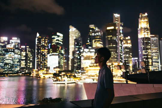 Asian man watching the Singapore skyline at night