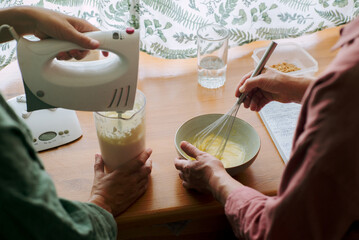 Unrecognizable women cooking together in stylish kitchen