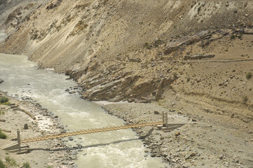 A wooden suspension bridge over beautiful river in Ladakh, INDIA.