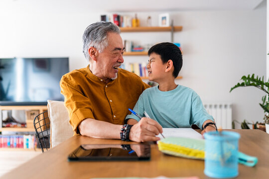 Grandfather teaches child looking each at other - Powered by Adobe