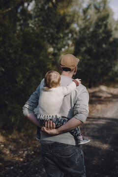 Man piggy backing child with back to camera.