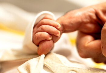 newborn Baby is Holding Father Hand