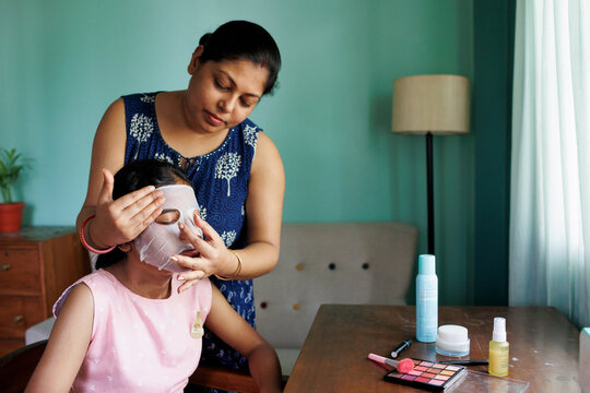 Mother applying facemask to her daughters face for skincare