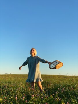 The happy girl on the field with basket.