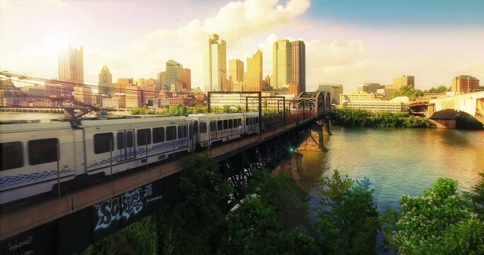 A simulated morning sunrise aerial establishing shot of the Pittsburgh skyline as a subway train travels in the foreground.	
