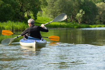 Family kayak trip for seigneur and senora. An elderly married couple rowing a boat on the river, a...