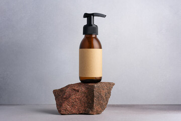 Fototapeta na wymiar Brown glass bottle standing on stone for cosmetic product mock up