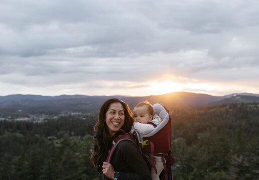 Woman and baby in carrier outside on hike.