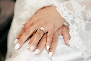 Close-up of a beautiful wedding ring with a precious stone on the bride's finger. Luxurious wedding...