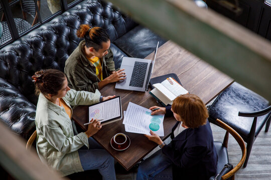 Business coworkers in a meeting with female consultant at cafe