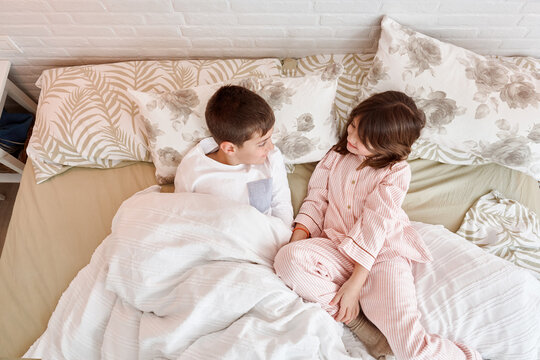 Brother and sister playing in bed