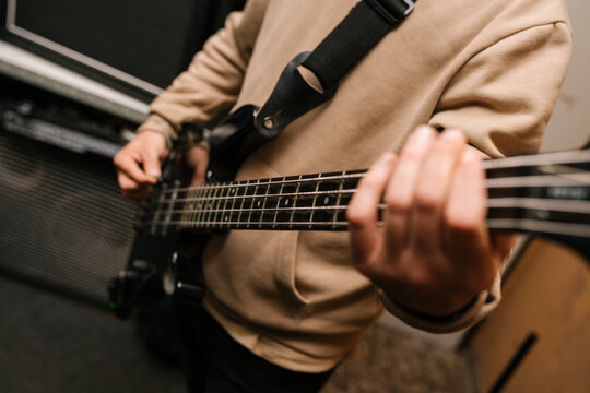 Unrecognizable musician playing bass guitar