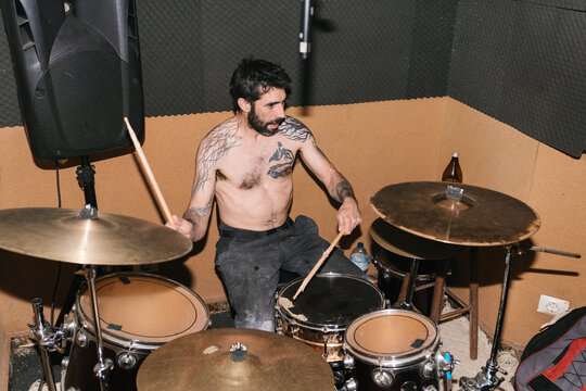 Male drummer performing beats with drumsticks