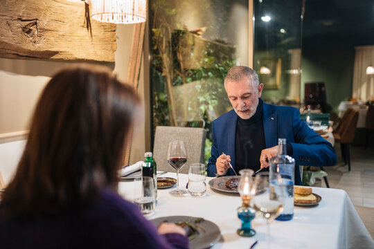 Calm Senior Couple Having Romantic Dinner In Restaurant