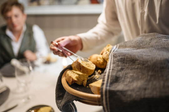 Unrecognizable man serving delicious bread with tongs