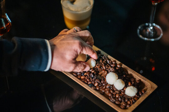 Man picking snacks with roasted groundnut seeds on tray