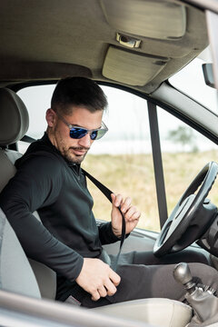 Man fastening his seat belt in the car.