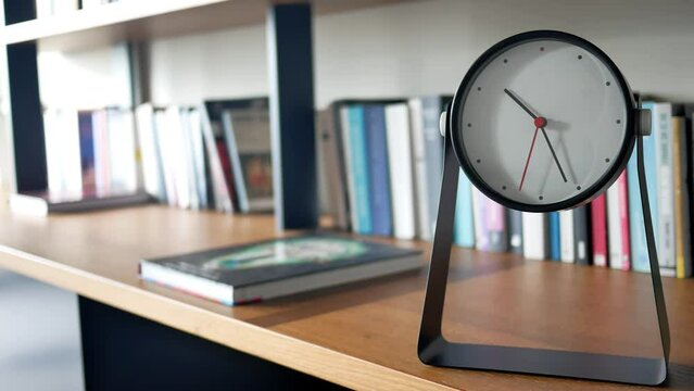 simple modern clock on a book shelf .