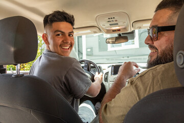 Latinx father teaching his son to drive 