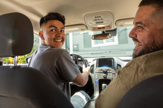 Latinx father teaching his son to drive 