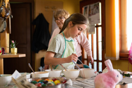 Grandma And Grandchildren Painting Eggs For Easter. Family Activity.