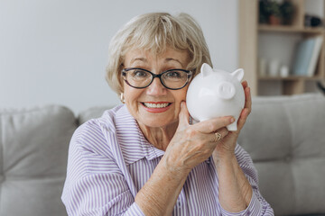 savings, money, annuity insurance, retirement and people concept - smiling senior woman putting...