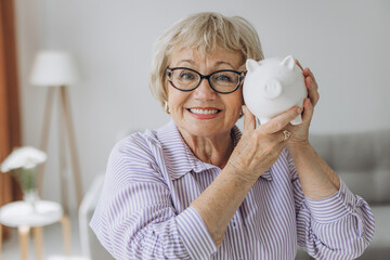 savings, money, annuity insurance, retirement and people concept - smiling senior woman putting...
